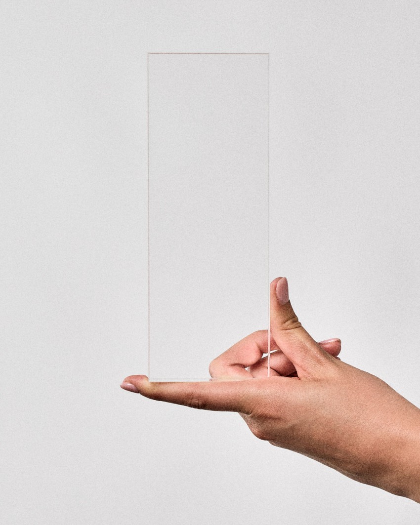 Trofeo de metacrilato tótem VITRA L rectangular para personalizar, sostenido por una modelo