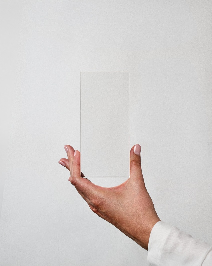 Trofeo de metacrilato tótem VITRA M rectangular para personalizar, sostenido por una modelo