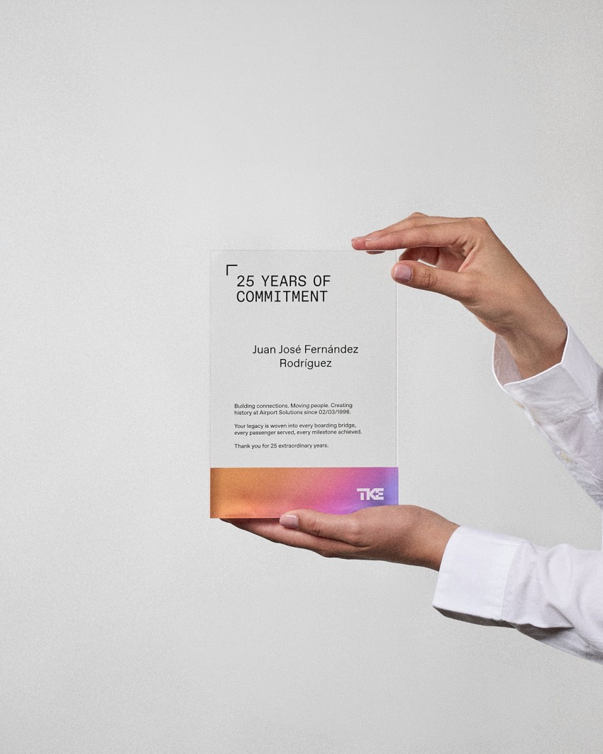 Personalized acrylic award plaque in VITRA A5 format, held by a model